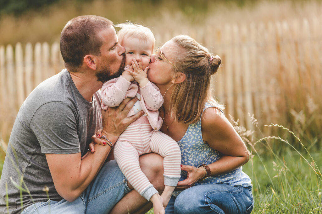 Mutter Vater und Tochter auf Wiese. Familienfotograf Freiburg