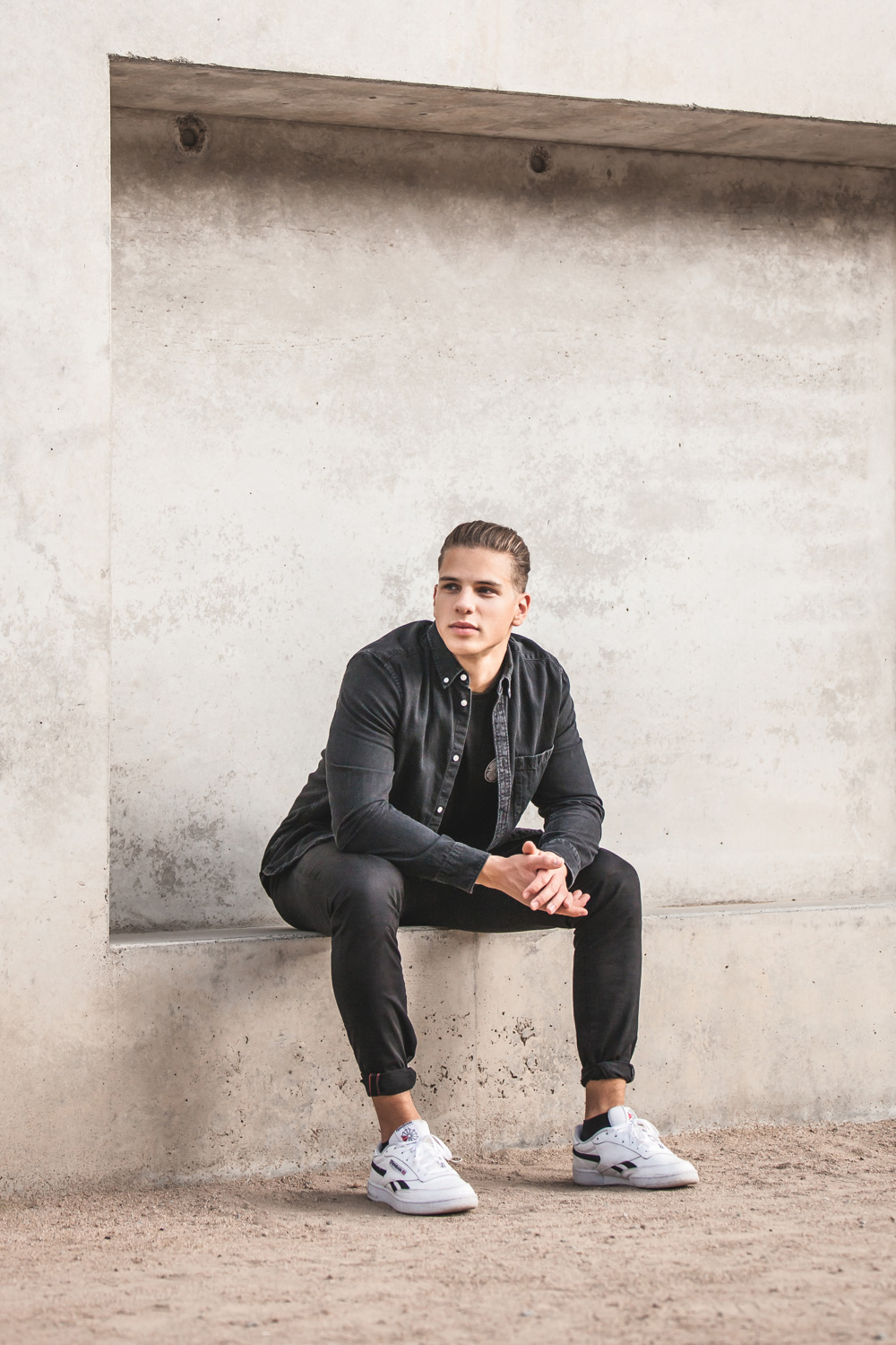 Junger Mann vor Mauer